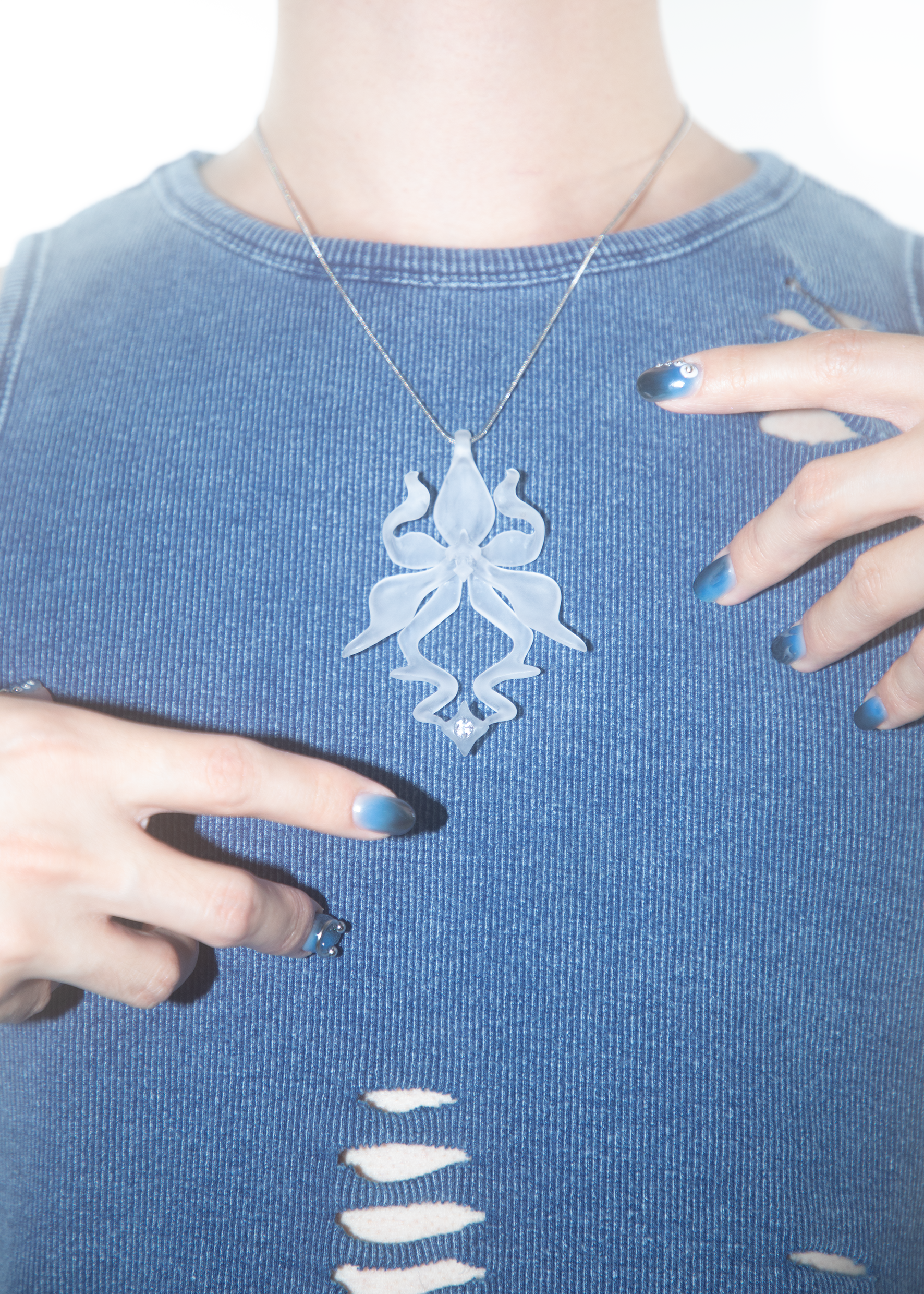Model wearing translucent/transparent 3D printed resin orchid necklace with gemstone