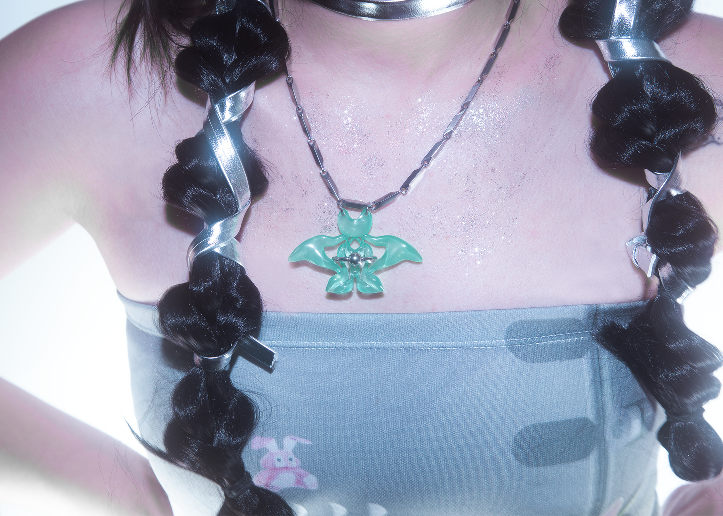Model wearing 3D printed cat-butterfly necklace with jade-like green finish and piecering