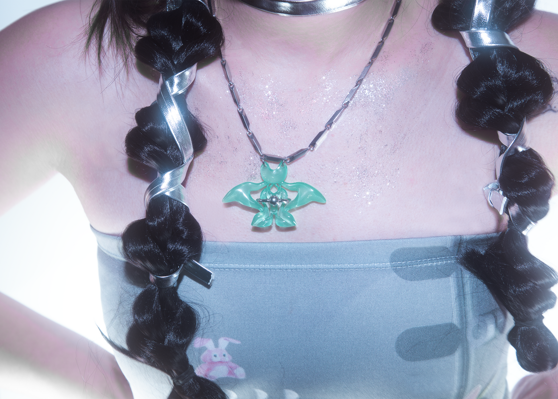 Model wearing 3D printed cat-butterfly necklace with jade-like green finish and piecering