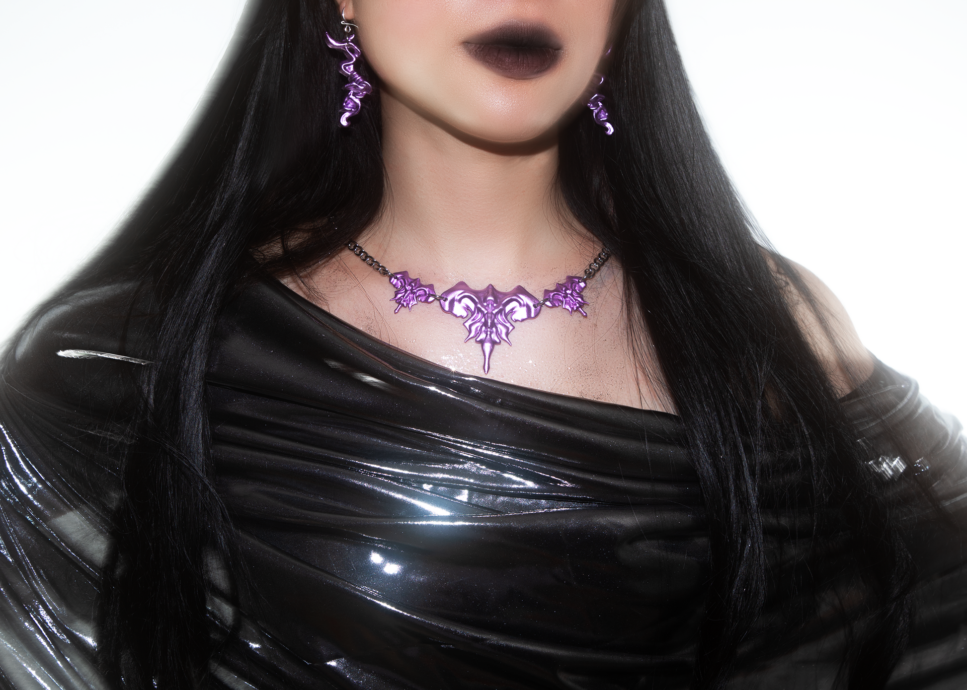 Model wearing 3D printed necklace earrings set with purple metalic finish